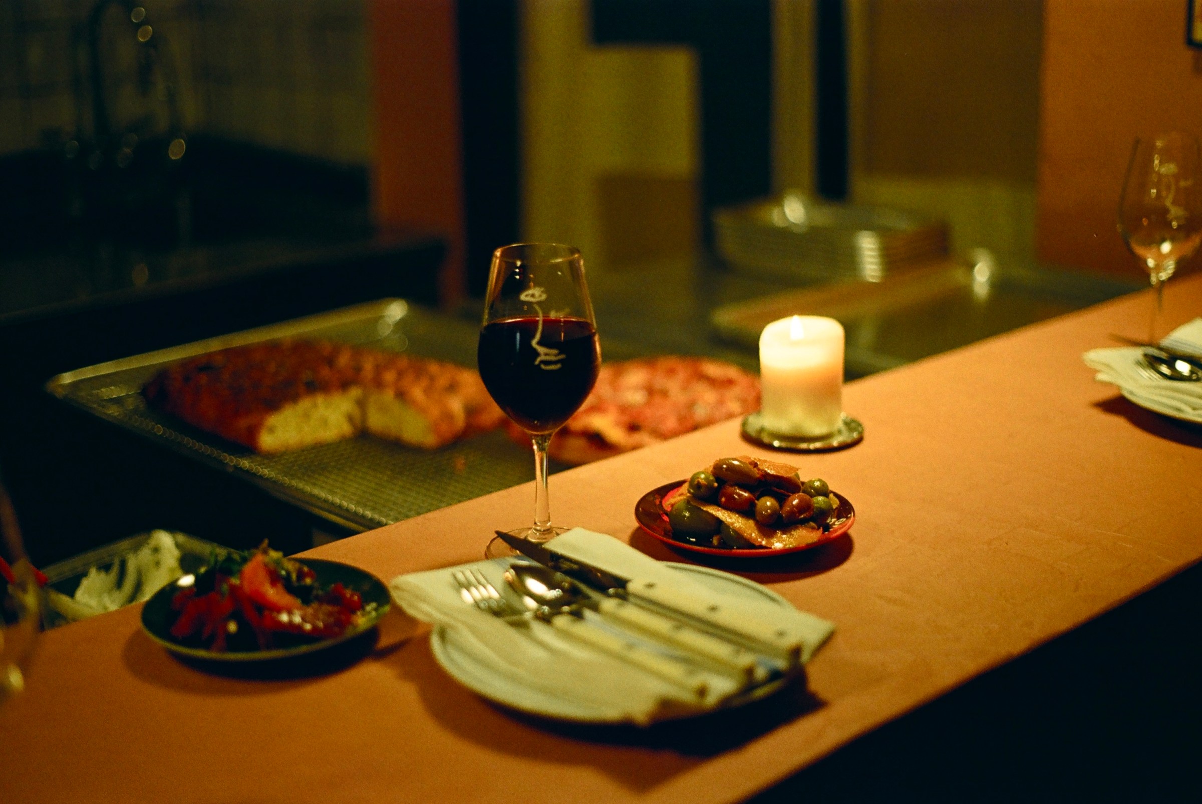 A place setting with wine and a plate of olives on a bar at Chenin in Detroit, Michigan.