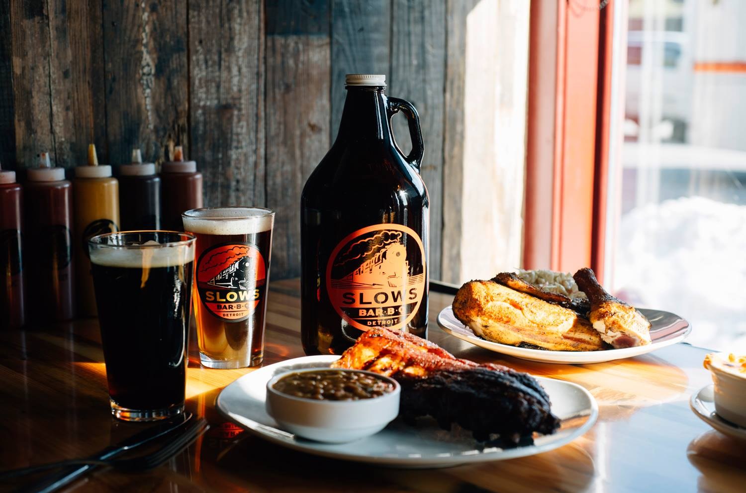 A plate of barbecue next to pints of beer.