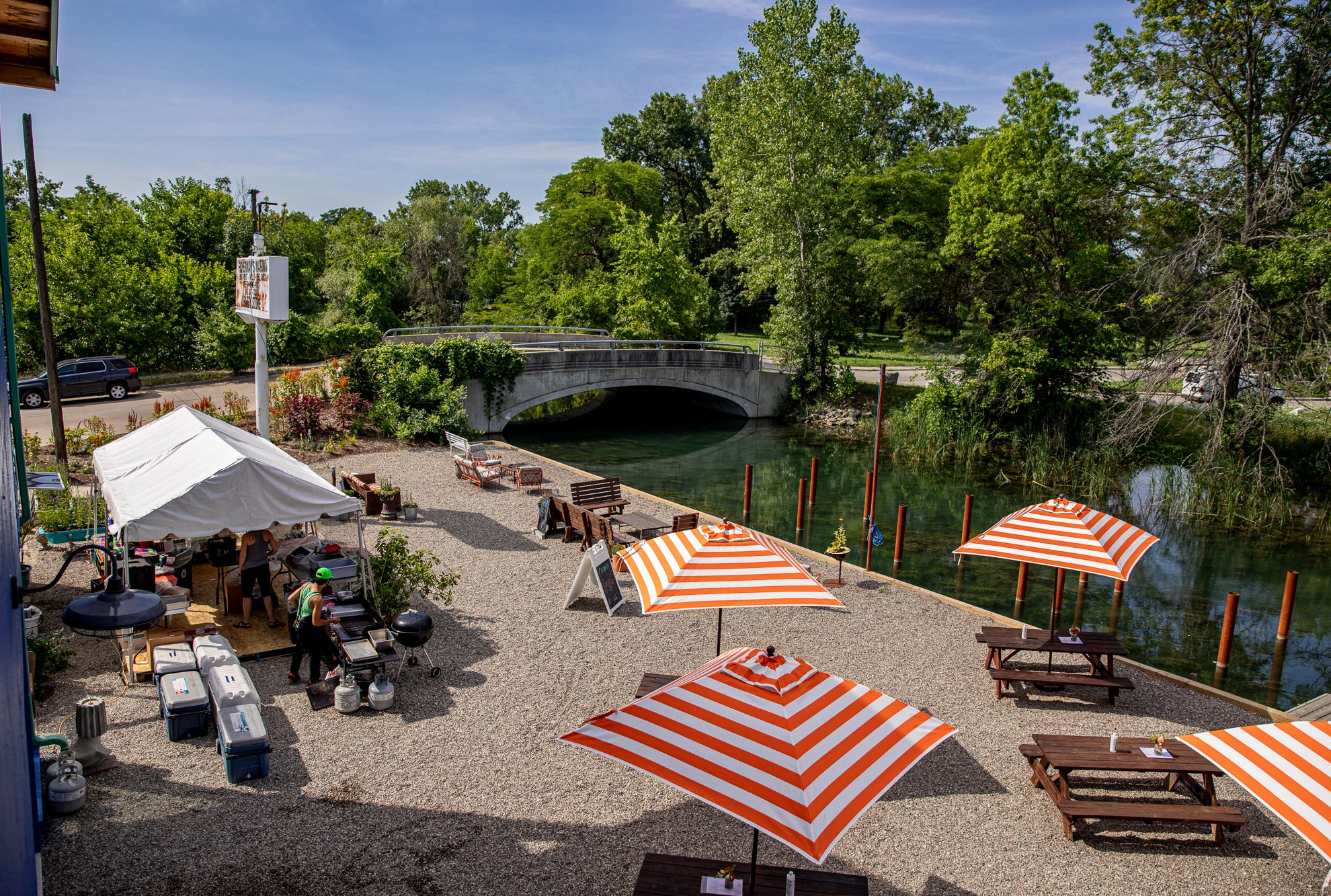 An overhead view of the grill setup and socially distance picnic tables at Coriander on a sunny day.
