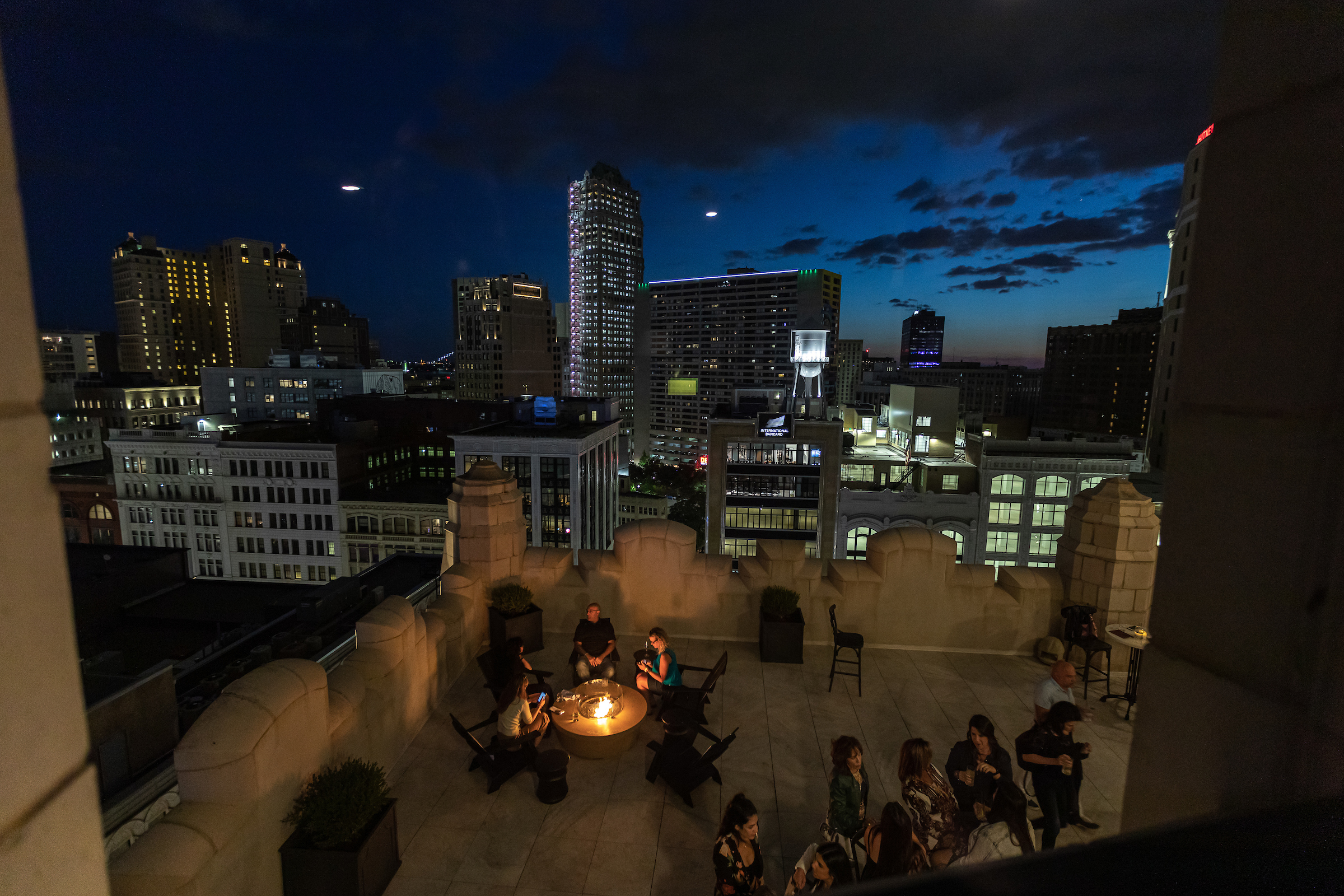 Customers gather around a firepit on the rooftop lounge of the Monarch Club in downtown Detroit on a fall evening.