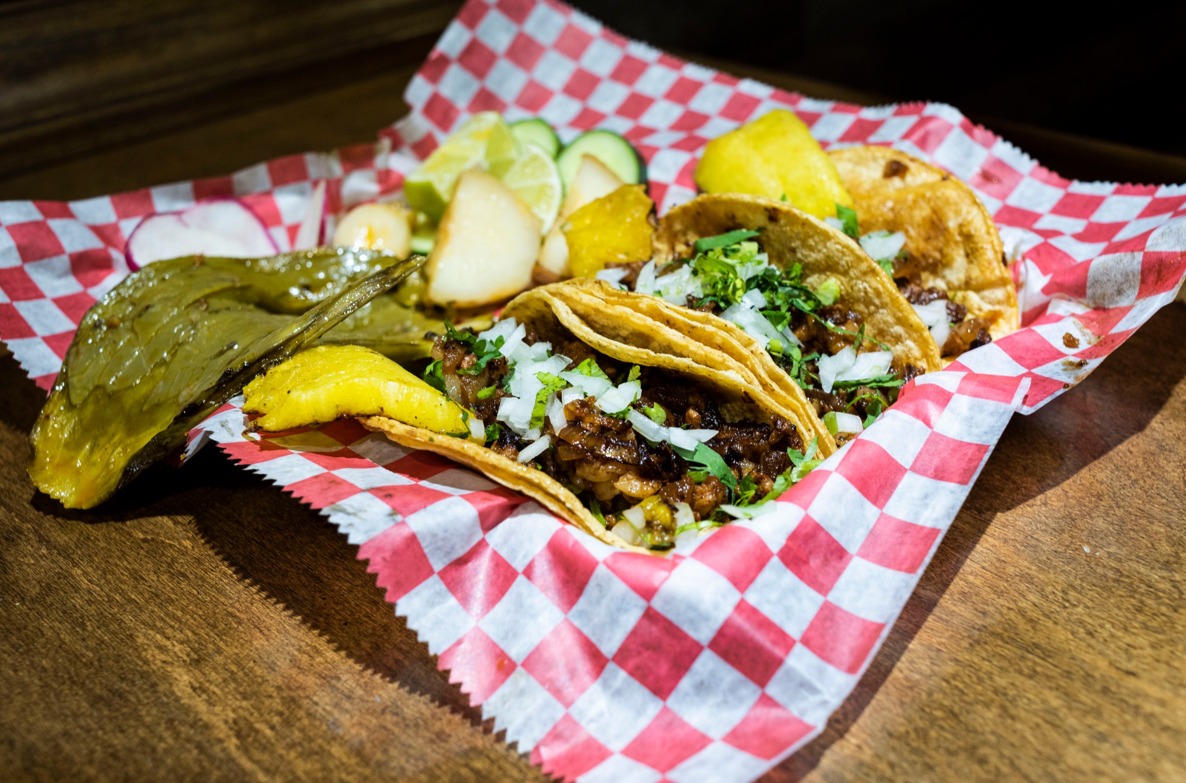 A plate of tacos on red and white checkered paper from La Palapa del Parian in Detroit, Michigan.
