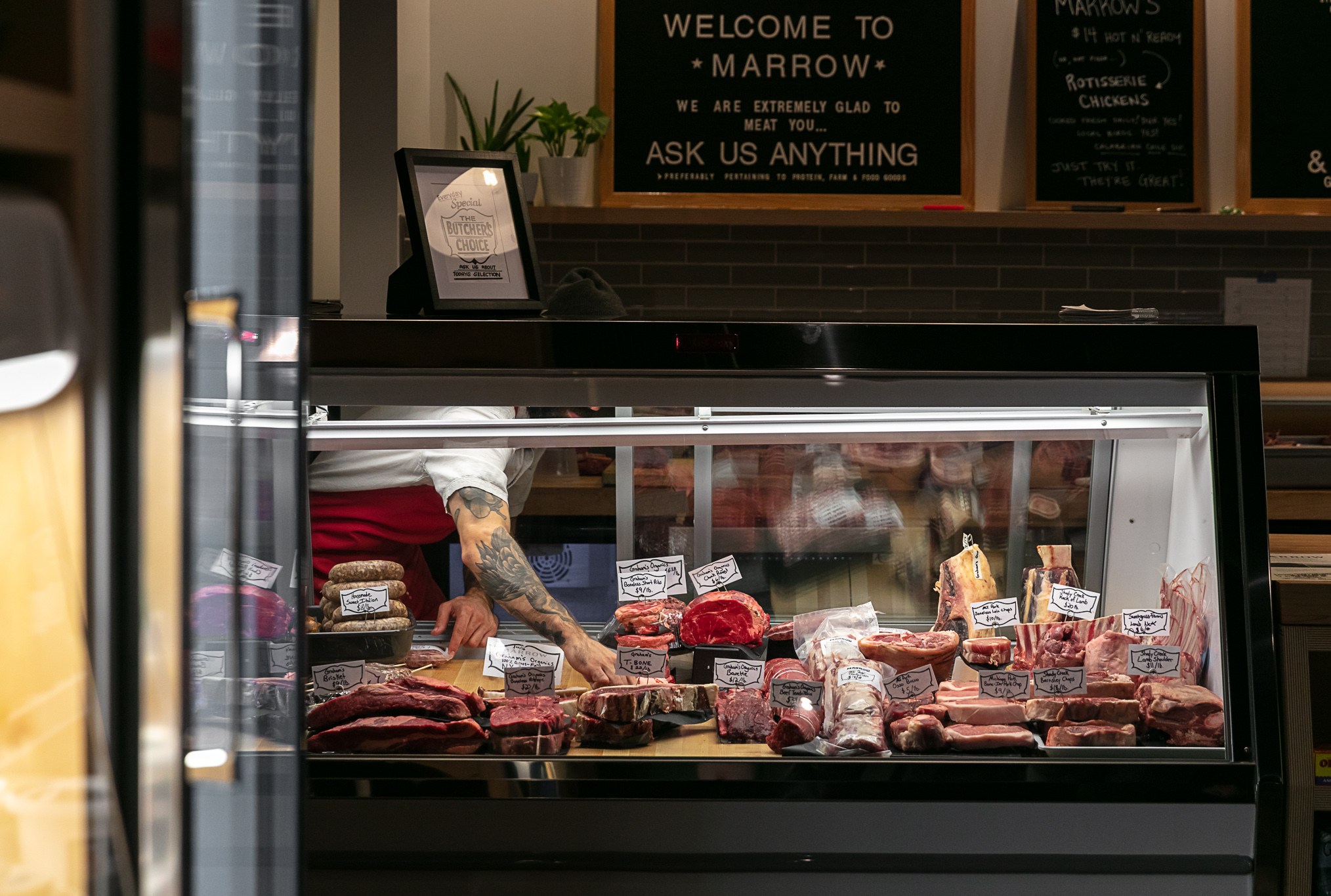 A tattooed arm reaches into the butcher case at Marrow.