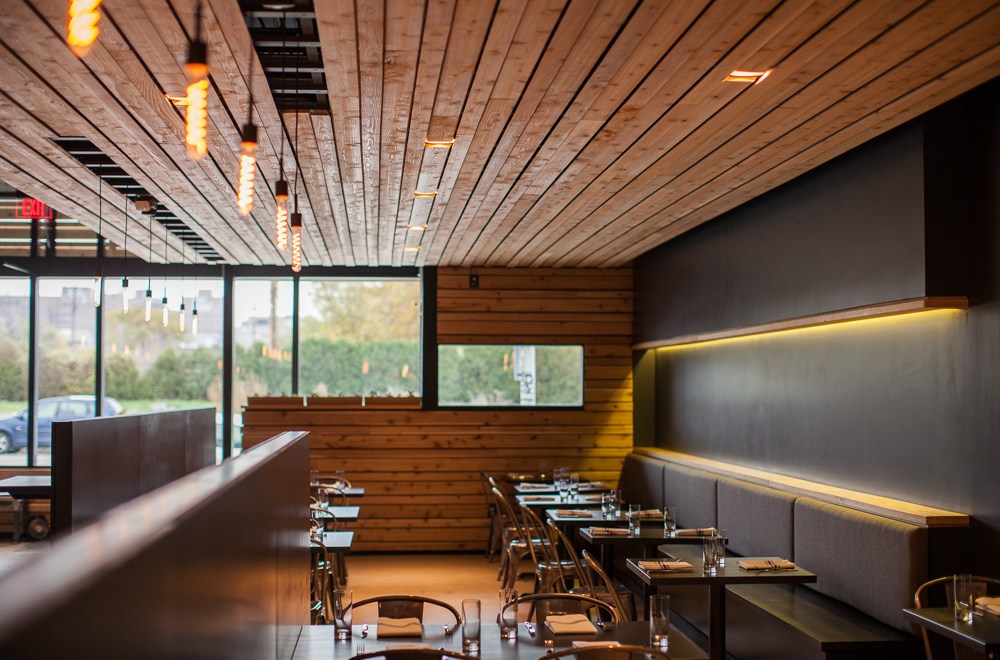 A dining room featuring windows, lighting, and wood accents at Selden Standard in Detroit, Michigan.