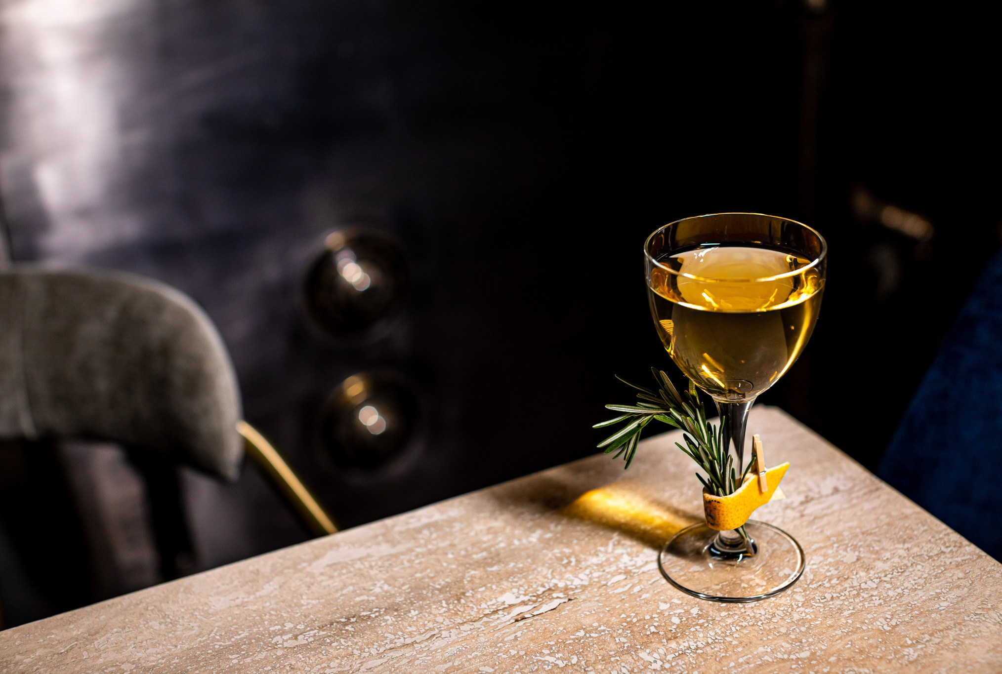 Mezcal and amontillado sherry cocktail Flashing Lights from the Shelby with a garnish of rosemary clip to the stem of the coup glass with a lemon peel