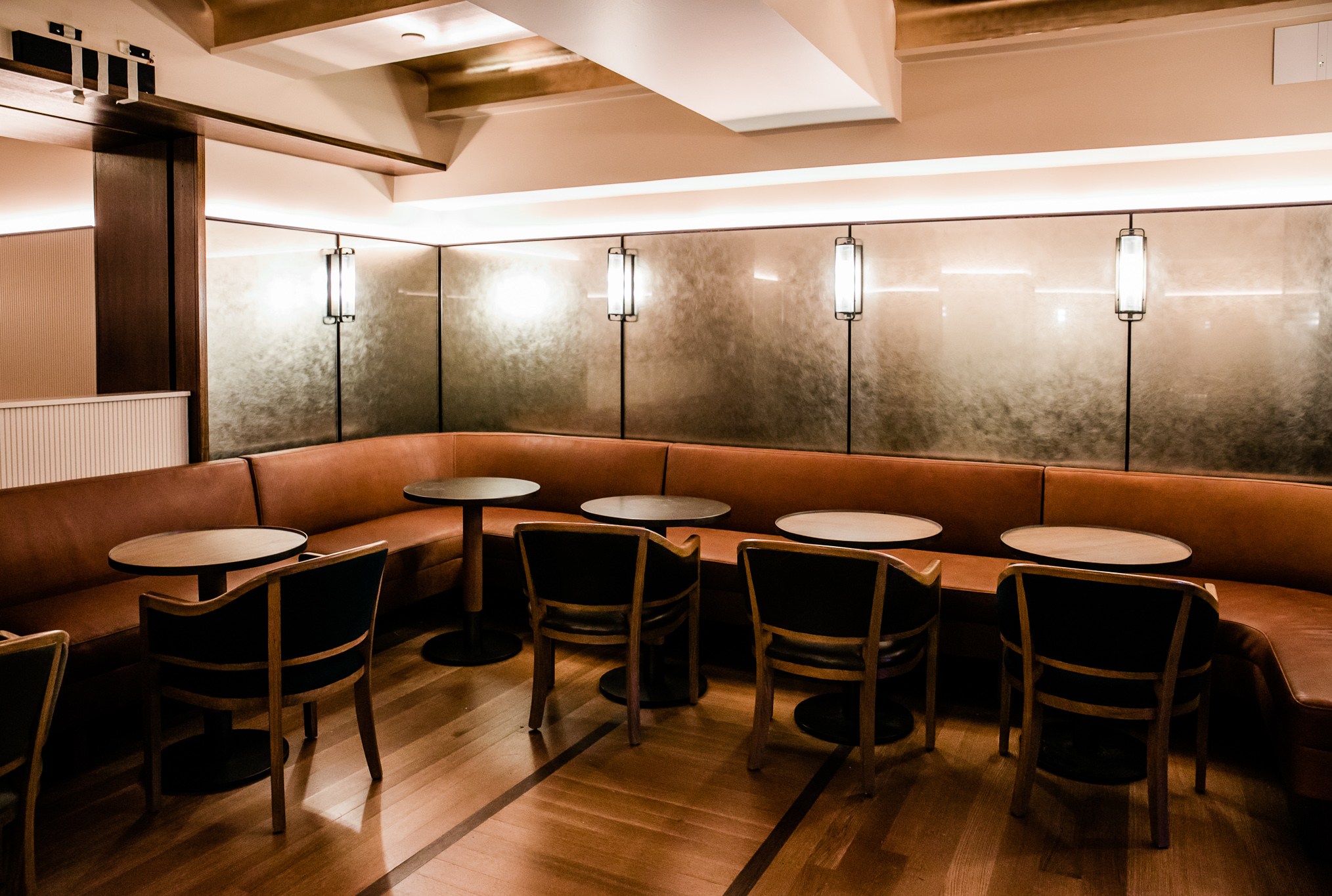 Evening bar features blush pink banquets with shimmery walls and low ceilings.
